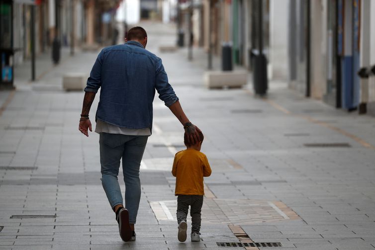 Pai e filho caminham juntos em meio a pandemia de covid-19 na Espanha.