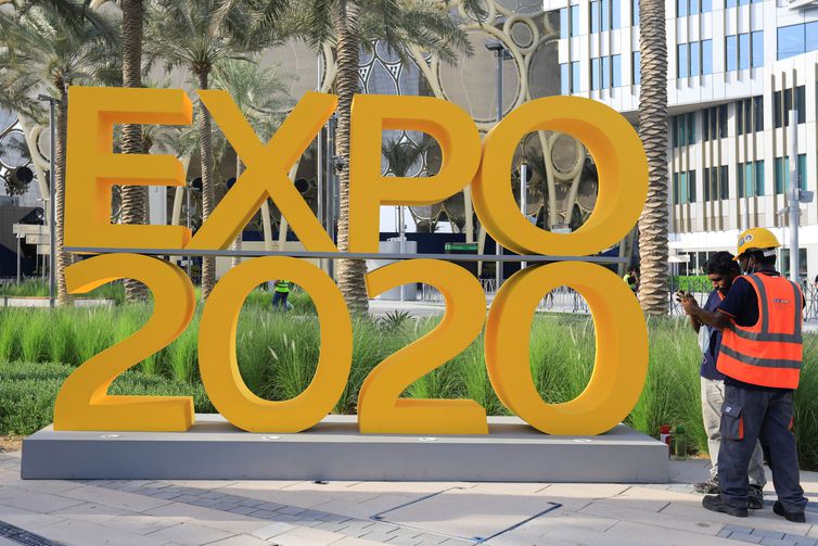 Workers are pictured next to the Expo 2020 logo ahead of the opening ceremony in Dubai