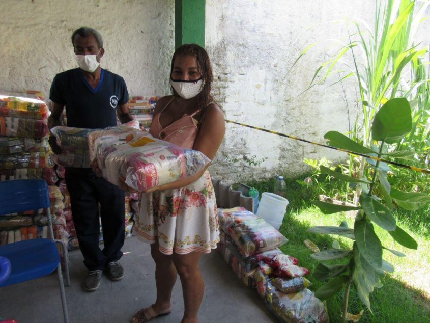 Beneficiária, Raquel Costa, recebe alimentos. Foto: Ascom Semas
