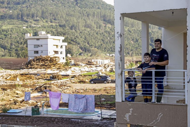 Muçum (RS), 22/06/2024 - Tiago Dalmolin e seus filhos na varanda da sua casa, após enchente que atingiu toda a região. Foto: Bruno Peres/Agência Brasil