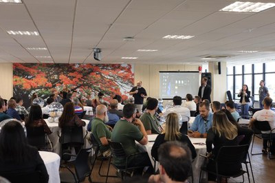 Imagem de grupo de pessoas em uma sala. 