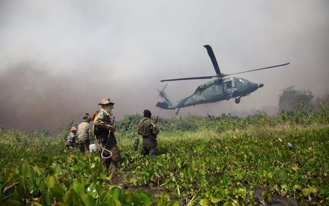 Helicóptero resgata militares cercados por fogo em incêndio; veja fotos