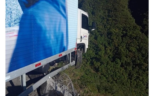 À beira de precipício: caminhão fica pendurado em mureta de rodovia