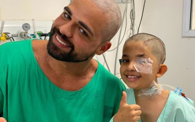 Paciente de 8 anos que retirou tumor cerebral raspa cabelo de médico; assista